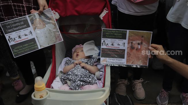 Pengungsi Afghanistan membawa poster saat menggelar aksi unjuk rasa di depan Gedung UNHCR, Kebon Sirih, Jakarta, Selasa (24/8/2021). [Suara.com/Angga Budhiyanto]