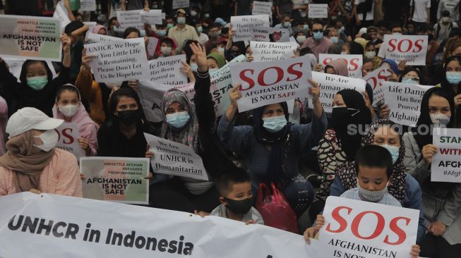 Pengungsi Afghanistan membawa poster saat menggelar aksi unjuk rasa di depan Gedung UNHCR, Kebon Sirih, Jakarta, Selasa (24/8/2021). [Suara.com/Angga Budhiyanto]