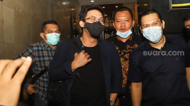 Musisi David Kurnia Albert atau David NOAH berjalan keluar usai menjalani pemeriksaan di Polda Metro Jaya, Jakarta Selatan, Selasa (24/8/2021). [Suara.com/Alfian Winanto]