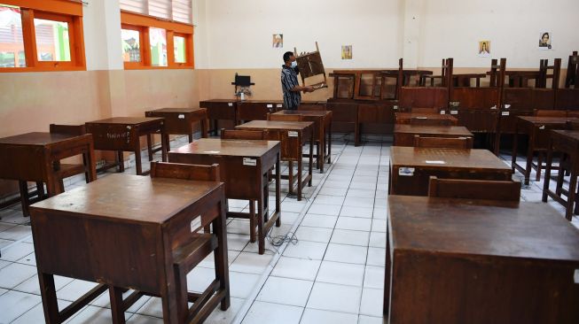 Pekerja menata bangku di ruang kelas sekolah di SMA Negeri 87, Jakarta, Selasa (24/8/2021). ANTARA FOTO/Hafidz Mubarak 