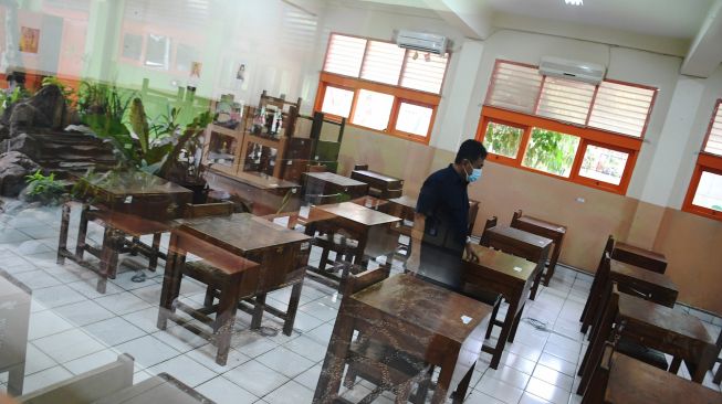 Pekerja menata bangku di ruang kelas sekolah di SMA Negeri 87, Jakarta, Selasa (24/8/2021). ANTARA FOTO/Hafidz Mubarak 