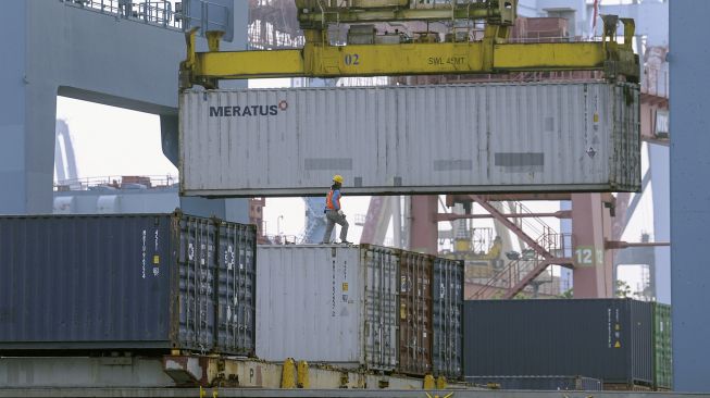 Seorang pekerja menyaksikan bongkar muat peti kemas di Pelabuhan Tanjung Priok, Jakarta, Selasa (24/8/2021).  ANTARA FOTO/M Risyal Hidayat