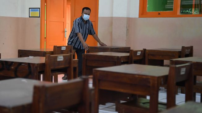 Pekerja menata bangku di ruang kelas sekolah di SMA Negeri 87, Jakarta, Selasa (24/8/2021). ANTARA FOTO/Hafidz Mubarak 