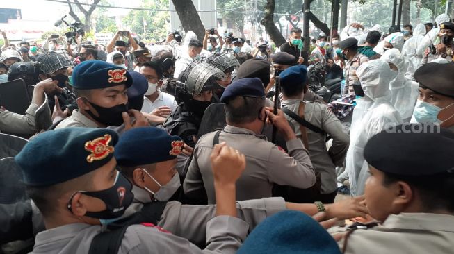 Aparat kepolisian saat bentrok dengan ratusan imigran Afghanistan yang berdemo di kantor UNHCR, Jakarta. (Suara.com/Yaumal)