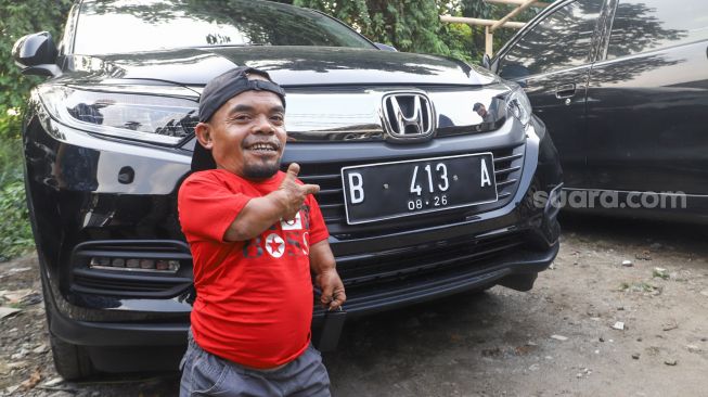 Komedian Ucok Baba berpose didepan mobil barunya saat ditemui di Cafenya di Kawasan Cipayung, Depok, Jawa Barat, Rabu (25/11/2021). [Suara.com/Alfian Winanto]