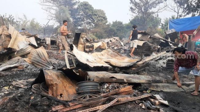 Sejumlah warga tengah mencari barang berharga diantara tumpukan sisa kebakaran di kawasan pemukiman pemulung, di Kelurahan Jurang Mangu Barat, Pondok Aren, Tangsel, Rabu (25/8/2021). [SuaraJakarta.id/Wivy Hikmatullah]