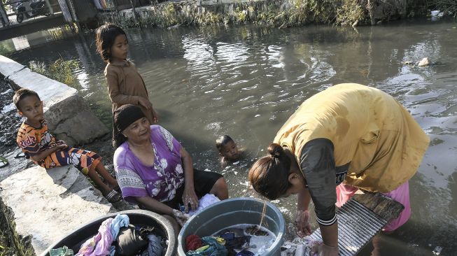 Sejumlah warga mencuci pakaian di aliran kali Blencong, Sukatani, Kabupaten Bekasi, Jawa Barat, Kamis (26/8/2021).  ANTARA FOTO