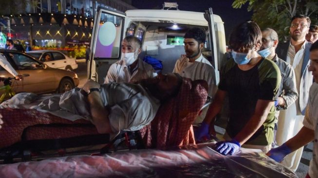 Sejumlah korban dievakuasi menggunakan ambulans usai bandara Kabul diguncang dua ledakan pada Kamis (26/8/2021) waktu setempat. (Foto: AFP)