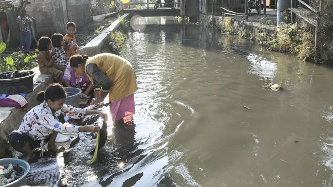 Sejumlah warga mencuci pakaian di aliran kali Blencong, Sukatani, Kabupaten Bekasi, Jawa Barat, Kamis (26/8/2021).  ANTARA FOTO