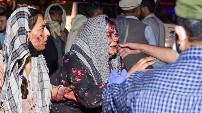 Perempuan menangis histeris dengan wajah penuh bercak darah usai bandara Kabul diguncang dua ledakan tewaskan 60 orang. (Foto: AFP)