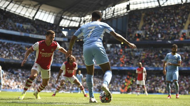 Gelandang Manchester City Raheem Sterling (tengah) mengontrol bola selama pertandingan sepak bola Liga Premier Inggris antara Manchester City dan Arsenal di Stadion Etihad, Manchester, Inggris, pada (28/8/2021). [Oli SCARFF / AFP]