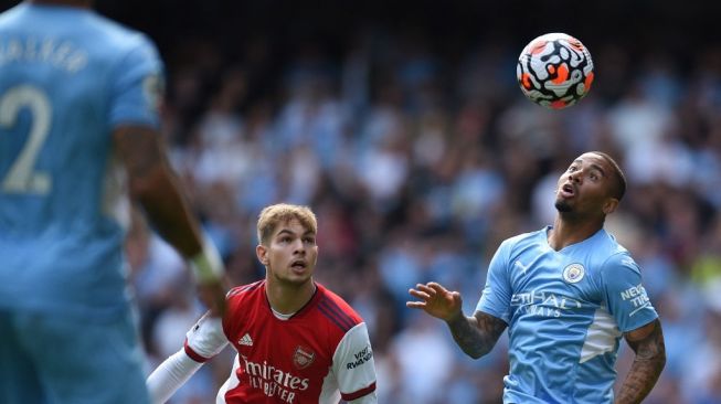 Gelandang Arsenal, Emile Smith Rowe (kiri) memperebutkan bola dengan striker Manchester City asal Brasil Gabriel Jesus selama pertandingan pekan ketiga Liga Inggris 2021/2022 antara Manchester City vs Arsenal di Stadion Etihad di Manchester, barat laut Inggris, pada 28 Agustus 2021.Oli SCARFF / AFP.