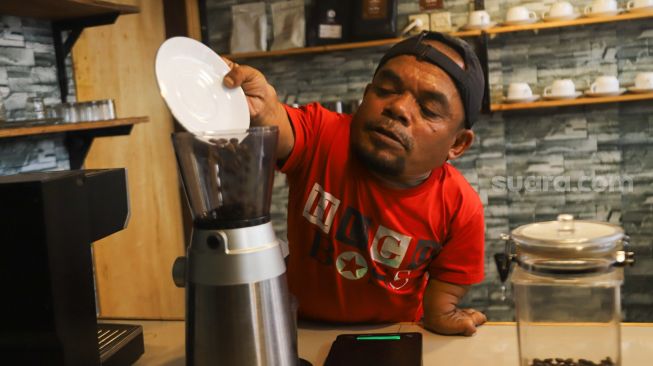 Komedian Ucok Baba meracik kopi spesial buatannya saat ditemui di Cafenya di Kawasan Cipayung, Depok, Jawa Barat, Rabu (25/8/2021). [Suara.com/Alfian Winanto]