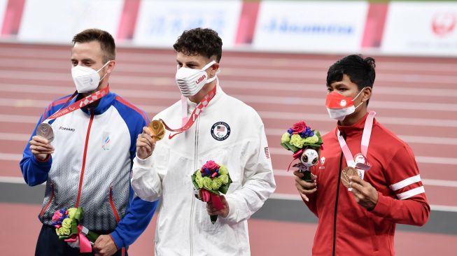 Pelari Indonesia Sapto Yogo Purnomo berpose dengan medali perunggu nomor lari 100 meter Paralimpiade Tokyo 2020 di Stadion Nasional Tokyo, jepang, Jumat (27/8/2021).  ANTARA FOTO
