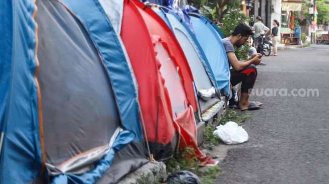 Pencari Suaka asal Afghanistan beraktivitas di depan tendanya di Kebon Sirih, Jakarta Pusat, Sabtu (28/8/2021). [Suara.com/Alfian Winanto]