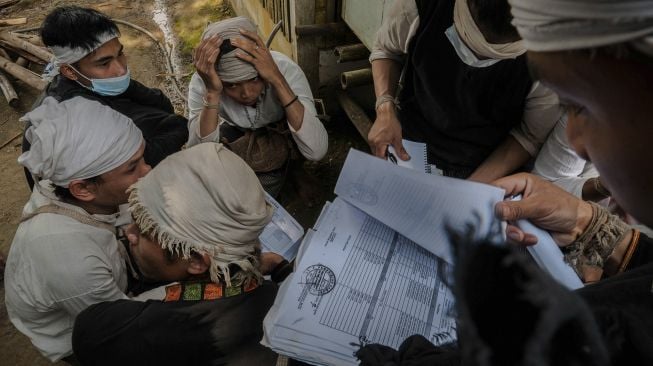 Warga Suku Baduy Dalam menyiapkan dokumen sebelum melakukan perekaman data KTP Elektronik warga suku Baduy di Kampung Cijahe, Lebak, Banten, Sabtu (28/8/2021). [ANTARA FOTO/Muhammad Bagus Khoirunas]