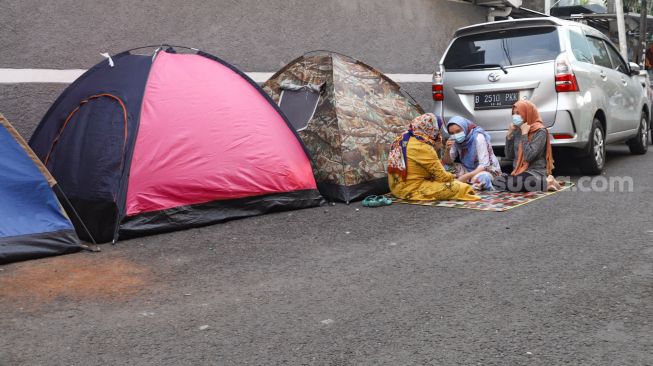 Pencari Suaka asal Afghanistan beraktivitas di depan tendanya di Kebon Sirih, Jakarta Pusat, Sabtu (28/8/2021). [Suara.com/Alfian Winanto]