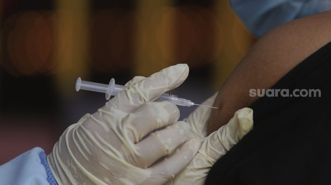 Vaksinator menyuntikkan vaksin COVID-19 kepada warga di Vihara Avalokitesvara, Mangga Besar, Jakarta, Minggu (29/8/2021). [Suara.com/Angga Budhiyanto]