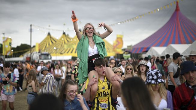 Para pengunjung festival menghadiri Festival Musik Reading di London, Inggris, pada (27/8/2021). [DANIEL LEAL-OLIVAS / AFP]