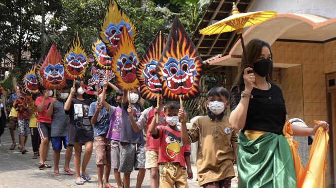 Seniman bersama anak-anak mengikuti kirab sambil membawa wayang saat Festival Lima Gunung (FLG) XX di Dusun Sudimoro, Baleagung, Grabag, Magelang, Jawa Tengah, Minggu (29/8/2021). [ANTARA FOTO/Anis Efizudin]