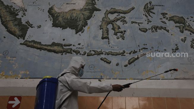 Petugas menyemprotkan cairan disinfektan di SDN Pondok Labu 14 Pagi, Jakarta, Senin (30/8/2021). [Suara.com/Angga Budhiyanto]