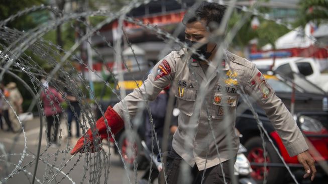 Polisi menata barikade kawat berduri dalam pengamanan sidang putusan banding Rizieq Shihab terkait perkara tes swab RS Ummi Bogor di Pengadilan Tinggi DKI Jakarta, Jakarta, Senin (30/8/2021). [ANTARA FOTO/Aditya Pradana Putra]