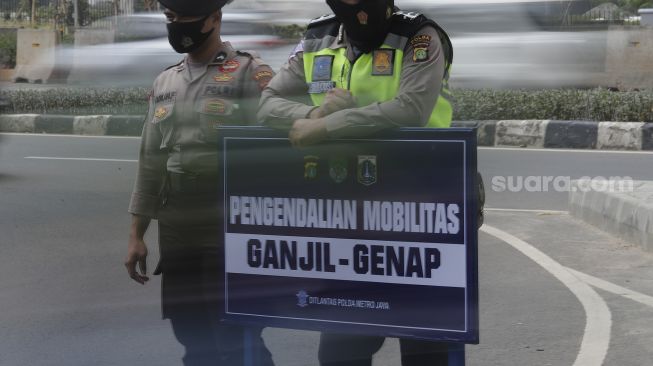 Police regulate vehicle traffic at the odd-even application post on Jalan HR Rasuna Said, Jakarta, Wednesday (1/9/2021). [Suara.com/Angga Budhiyanto]