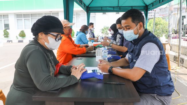 Warga membayar kepada petugas saat berbelanja pangan bersubsidi di Foodstation Pasar Induk Beras Cipinang, Jakarta Timur, Kamis (2/9/2021). [Suara.com/Alfian Winanto]