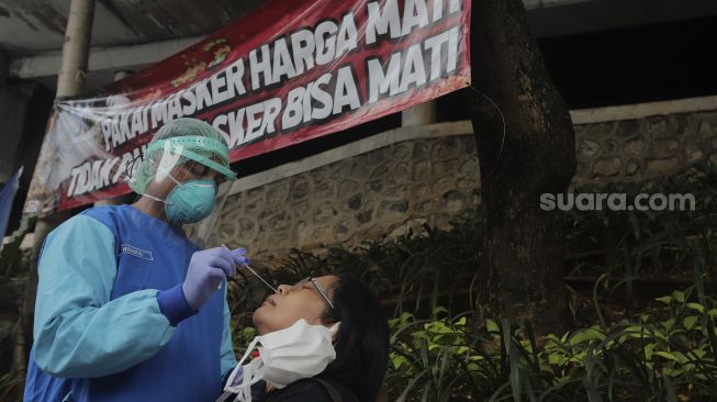 Petugas kesehatan melakukan tes usap (swab test) antigen dan PCR gratis di Terowongan Kendal, Menteng, Jakarta, Kamis (2/9/2021). [Suara.com/Angga Budhiyanto]