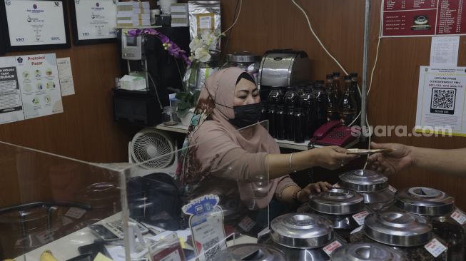 Penjual biji kopi melayani pembeli di Pasar Santa, Jakarta, Kamis (2/9/2021). [Suara.com/Angga Budhiyanto]