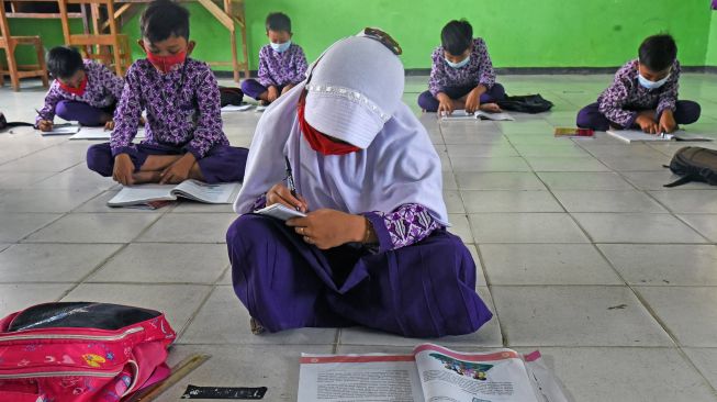 Sejumlah siswa belajar di lantai tanpa bangku dan meja belajar di SD Negeri Gelam 2 di Kampung Cigelam, Kecamatan Ciruas, Kabupaten Serang, Banten, Kamis (2/9/2021).  ANTARA FOTO/Asep Fathulrahman