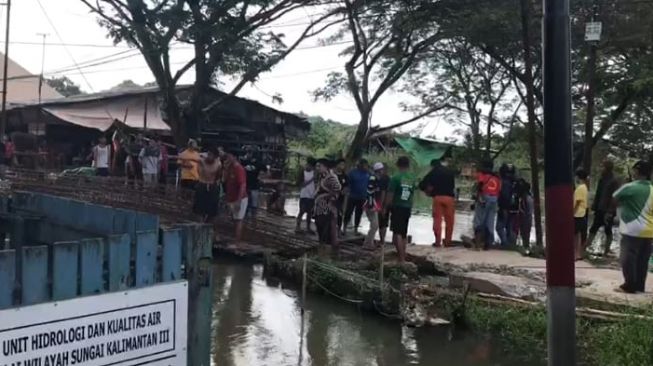 Pencarian jasad FS yang diketahui tenggelam di anak sungai jembatan Jalan Revolusi, Sungai Kunjang, Samarinda. [Suara.com/Apriskian Tauda Parulian]