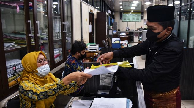 Sejumlah Aparatur Sipil Negara (ASN) mengenakan pakaian adat saat bekerja di Kantor Wali Kota Medan, Kota Medan, Sumatera Utara, Jumat (3/9/2021).  ANTARA FOTO/Fransisco Carolio