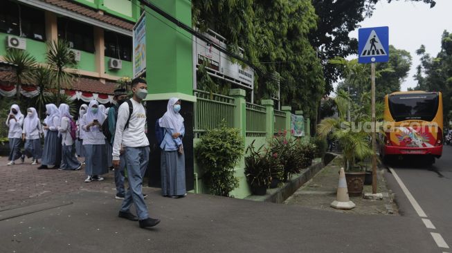 Pelajar bersiap menaiki Bus Sekolah Gratis usai mengikuti pembelajaran tatap muka (PTM) di SMK Negeri 15 Jakarta, Kebayoran Baru, Jakarta Selatan, Jumat (3/9/2021). [Suara.com/Angga Budhiyanto]