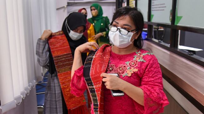 Sejumlah Aparatur Sipil Negara (ASN) mengenakan pakaian adat saat bekerja di Kantor Wali Kota Medan, Kota Medan, Sumatera Utara, Jumat (3/9/2021).  ANTARA FOTO/Fransisco Carolio