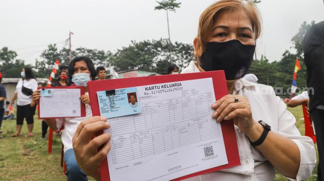 Warga Kebun Sayur menerima data kependudukan berupa KTP dan Kartu Keluarga di Ciracas, Jakarta Timur, Jumat (3/9/2021). [Suara.com/Alfian Winanto]