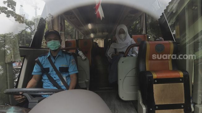 Pelajar menaiki Bus Sekolah Gratis usai mengikuti pembelajaran tatap muka (PTM) di SMK Negeri 15 Jakarta, Kebayoran Baru, Jakarta Selatan, Jumat (3/9/2021). [Suara.com/Angga Budhiyanto]