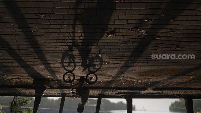 Seorang anak bersepeda di kawasan Perkampungan Budaya Betawi Setu Babakan, Jagakarsa, Jakarta, Minggu (5/9/2021). [Suara.com/Angga Budhiyanto]