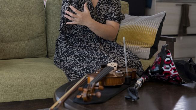 Biola dan lengan prostetik musisi Jepang Manami Ito terlihat saat dia berbicara selama wawancara di kediamannya di Shizuoka, Jepang, pada (28/8/2021). [Yuki IWAMURA / AFP]