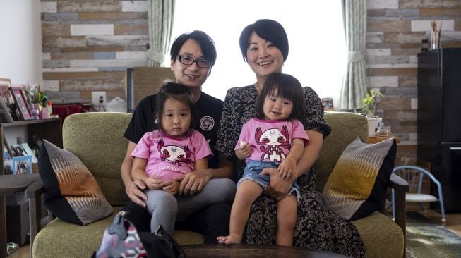 Pemain biola Jepang Manami Ito berpose bersama suaminya Yuki dan dua putri mereka Miu dan Mei di kediaman mereka di Shizuoka, Jepang, pada (28/8/2021). [Yuki IWAMURA / AFP]