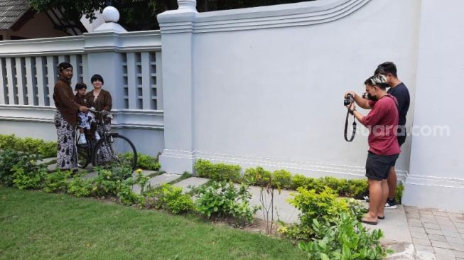 Fotografer yang tergabung dalam paguyuban Pokoke Blangkon mengarahkan wisatawan untuk berpose di sekitar Kantor Gubernur DIY dan Malioboro, Minggu (5/9/2021). - (SuaraJogja.id/Muhammad Ilham Baktora)