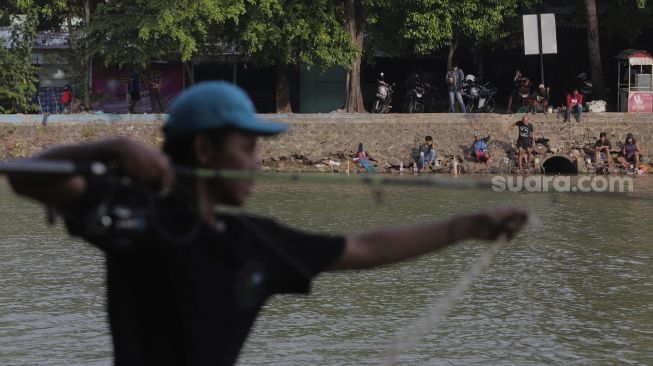 Sejumlah warga memancing ikan di tepi danau di kawasan Perkampungan Budaya Betawi Setu Babakan, Jagakarsa, Jakarta, Minggu (5/9/2021). [Suara.com/Angga Budhiyanto]