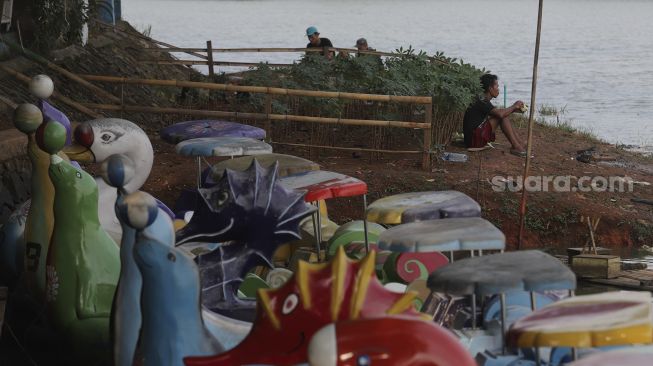 Warga beraktivitas di tepi danau di kawasan Perkampungan Budaya Betawi Setu Babakan, Jagakarsa, Jakarta, Minggu (5/9/2021). [Suara.com/Angga Budhiyanto]