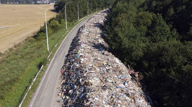 Foto udara menunjukkan tumpukan sampah yang ditinggalkan di jalan raya A601 di Juprelle, Liege, Belgia, pada (3/9/2021). [Kilian FICHOU / AFP] 