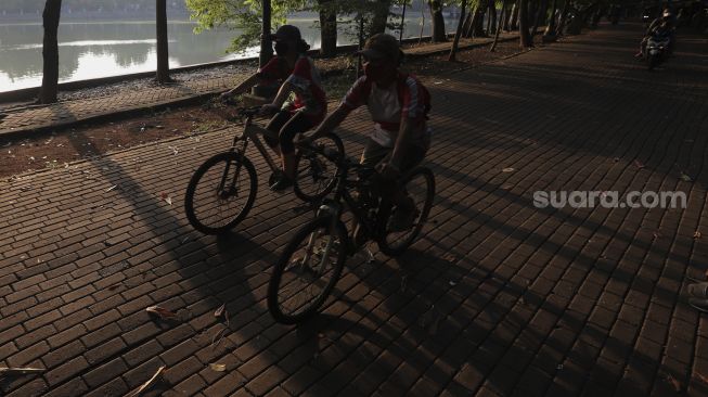 Warga bersepeda di kawasan Perkampungan Budaya Betawi Setu Babakan, Jagakarsa, Jakarta, Minggu (5/9/2021). [Suara.com/Angga Budhiyanto]