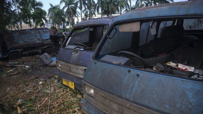 Seorang pekerja membawa potongan bagian angkot di Depok, Jawa Barat, Minggu (5/9/2021). [ANTARA FOTO/Wahyu Putro A]