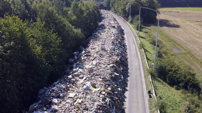 Foto udara menunjukkan tumpukan sampah yang ditinggalkan di jalan raya A601 di Juprelle, Liege, Belgia, pada (3/9/2021). [Kilian FICHOU / AFP] 