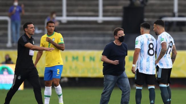 Dua pemain Argentina Nicolas Otamendi, Marcos Acuna sedang berbicara dengan seorang anggota otoritas kesehatan Brazil dalam pertandingan kualifikasi Piala Dunia 2022 zona Amerika selatan di Neo Quimica Arena, Sao Paulo, Brazil, Minggu (5/9/2021) waktu setempat. REUTERS/AMANDA PEROBELLI