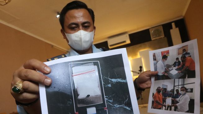 Kepala Kesatuan Pengaman Lembaga Pemasyarakatan (Lapas) Kelas IIA Kediri, Ario Galih Maduseno menunjukkan foto barang bukti narkotika dan tersangka pemiliknya di Kota Kediri, Jawa Timur, Senin (6/9/2021).  ANTARA FOTO/Prasetia Fauzani