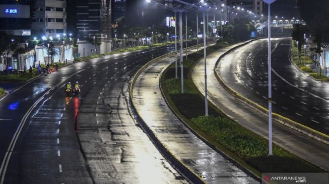 Petugas Kepolisian melakukan patroli saat diberlakukan "car free night" (malam bebas kendaraan) dan "crowd free night" (malam bebas keramaian) pada malam pergantian tahun di kawasan Jalan Sudirman, Jakarta, Kamis (31/12/2020). Polda Metro Jaya menutup sepanjang Jalan Sudirman-MH Thamrin, Jakarta pada malam pergantian tahun untuk mencegah kerumunan warga [ANTARA FOTO/Galih Pradipta/rwa]. 
